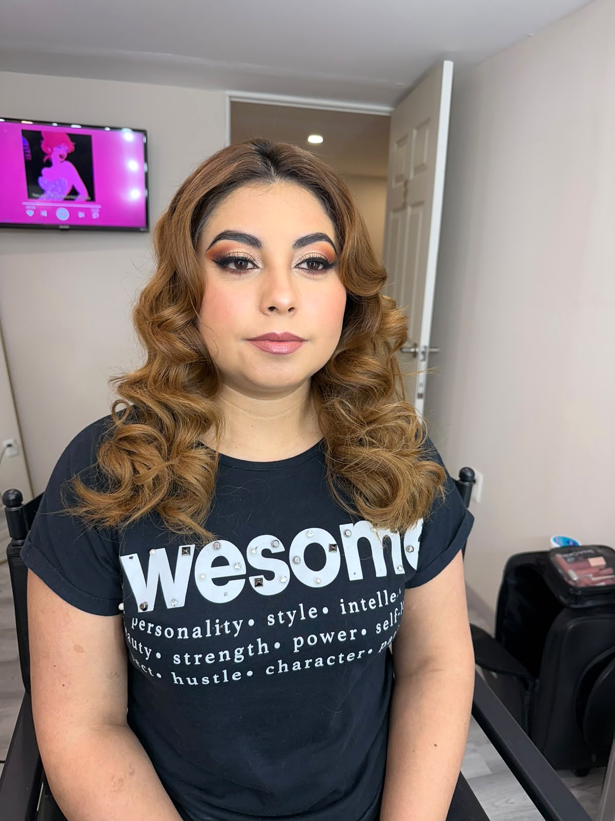 Maquillaje con delineado definido y cabello con ondas doradas